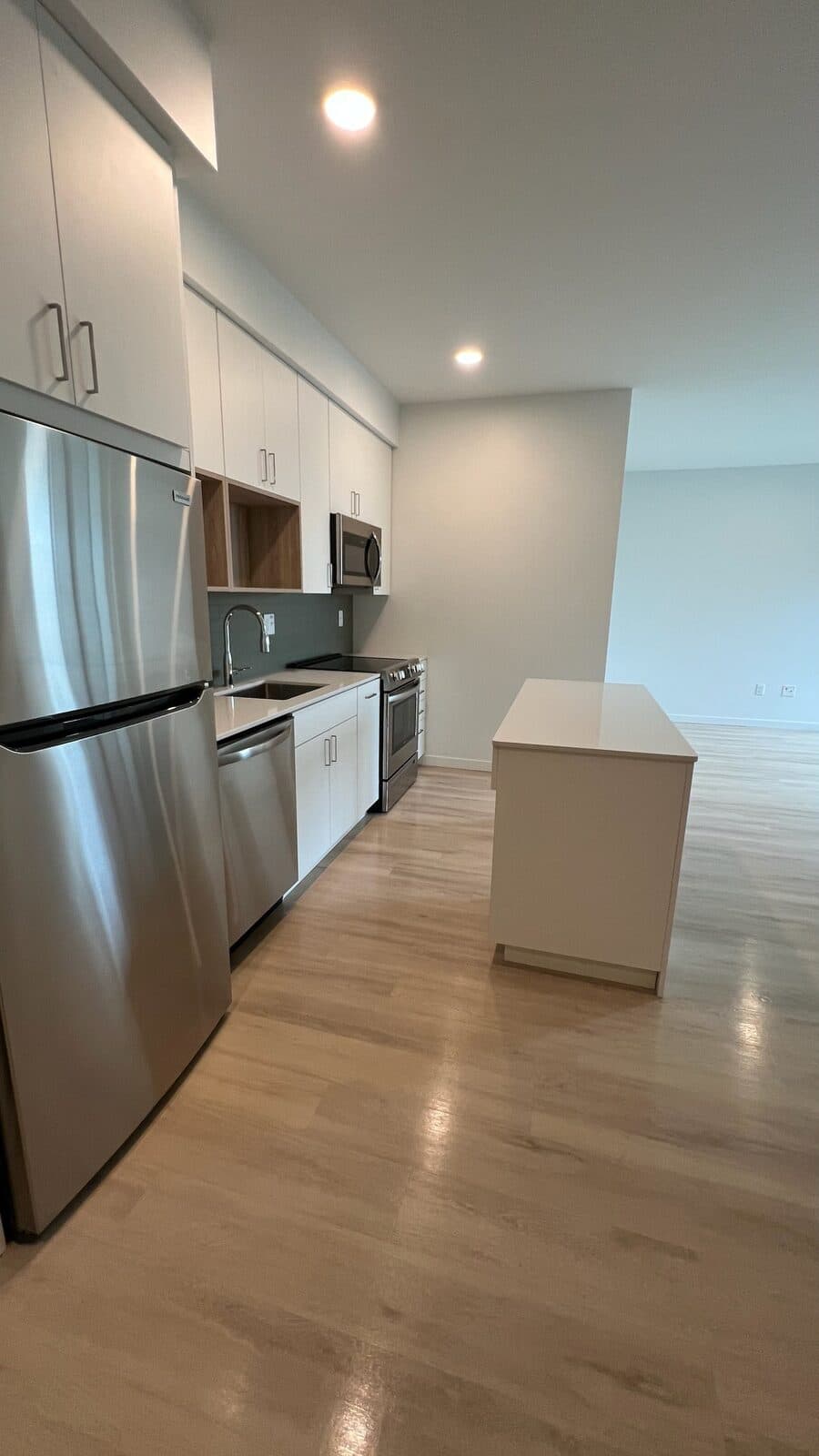 A freshly cleaned apartment kitchen with stainless appliances